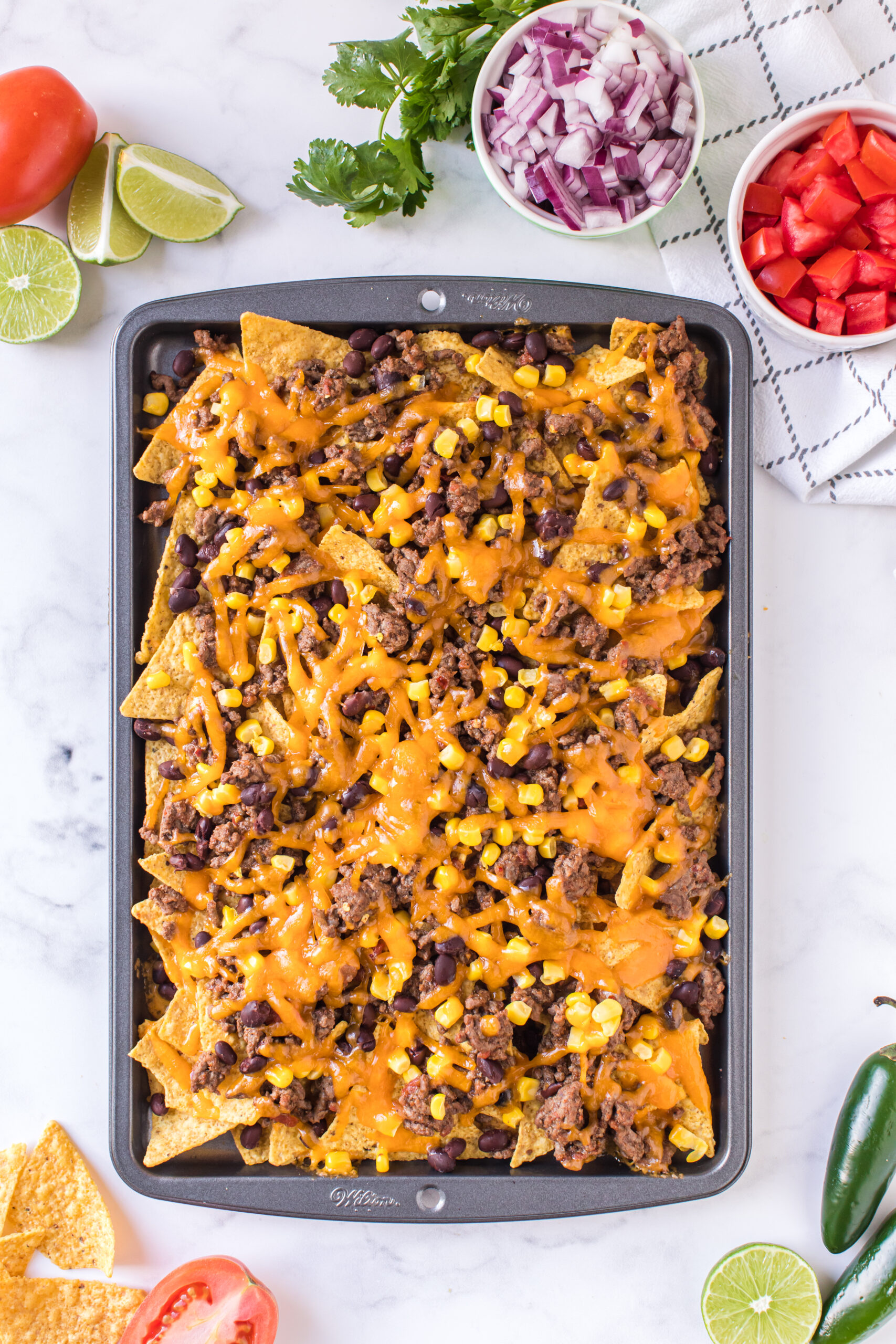 melted cheese on top of tray of nachos