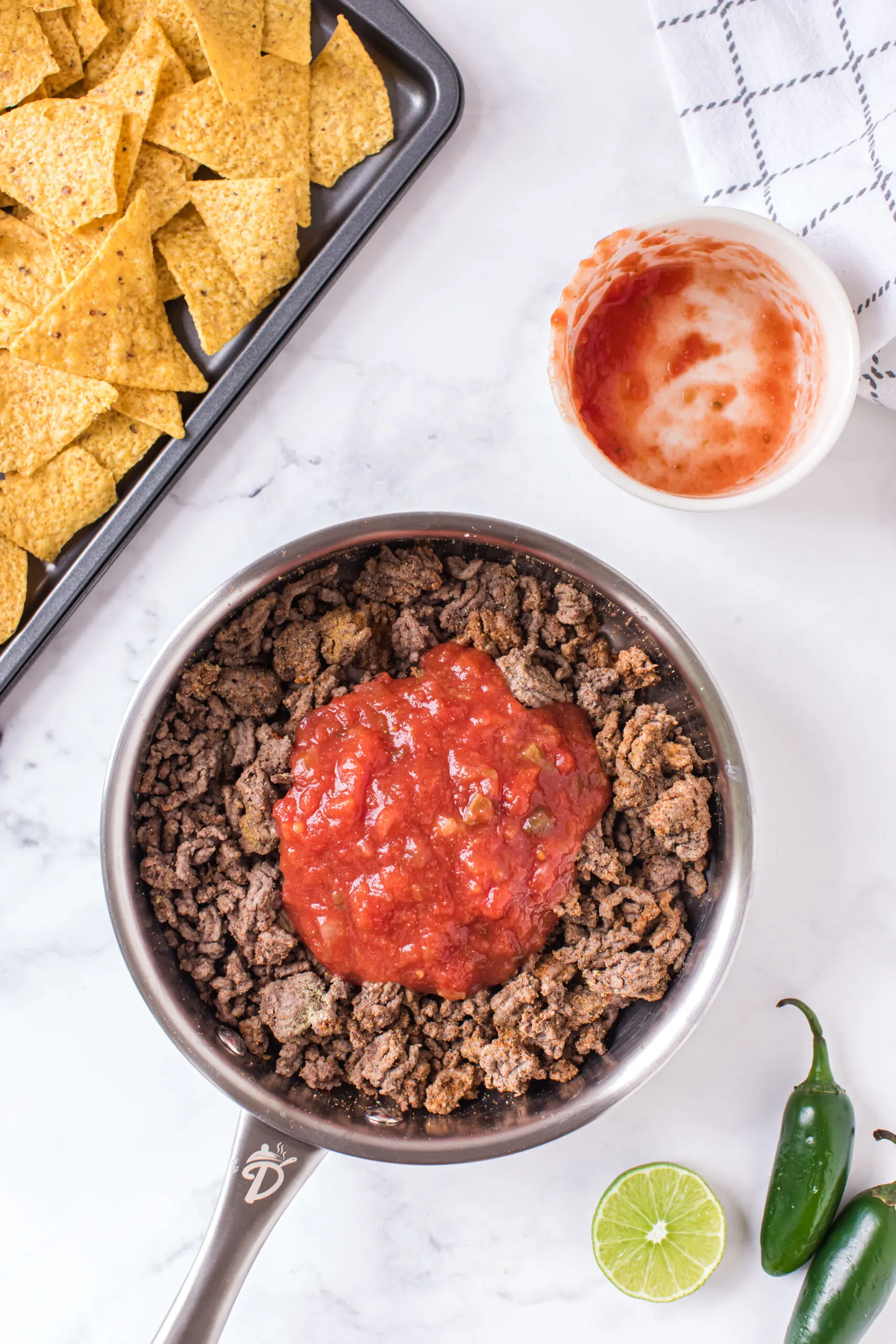 salsa added to a bowl of ground beef