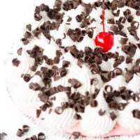 creamy pie topped with whipped topping, chocolate curls and a cherry