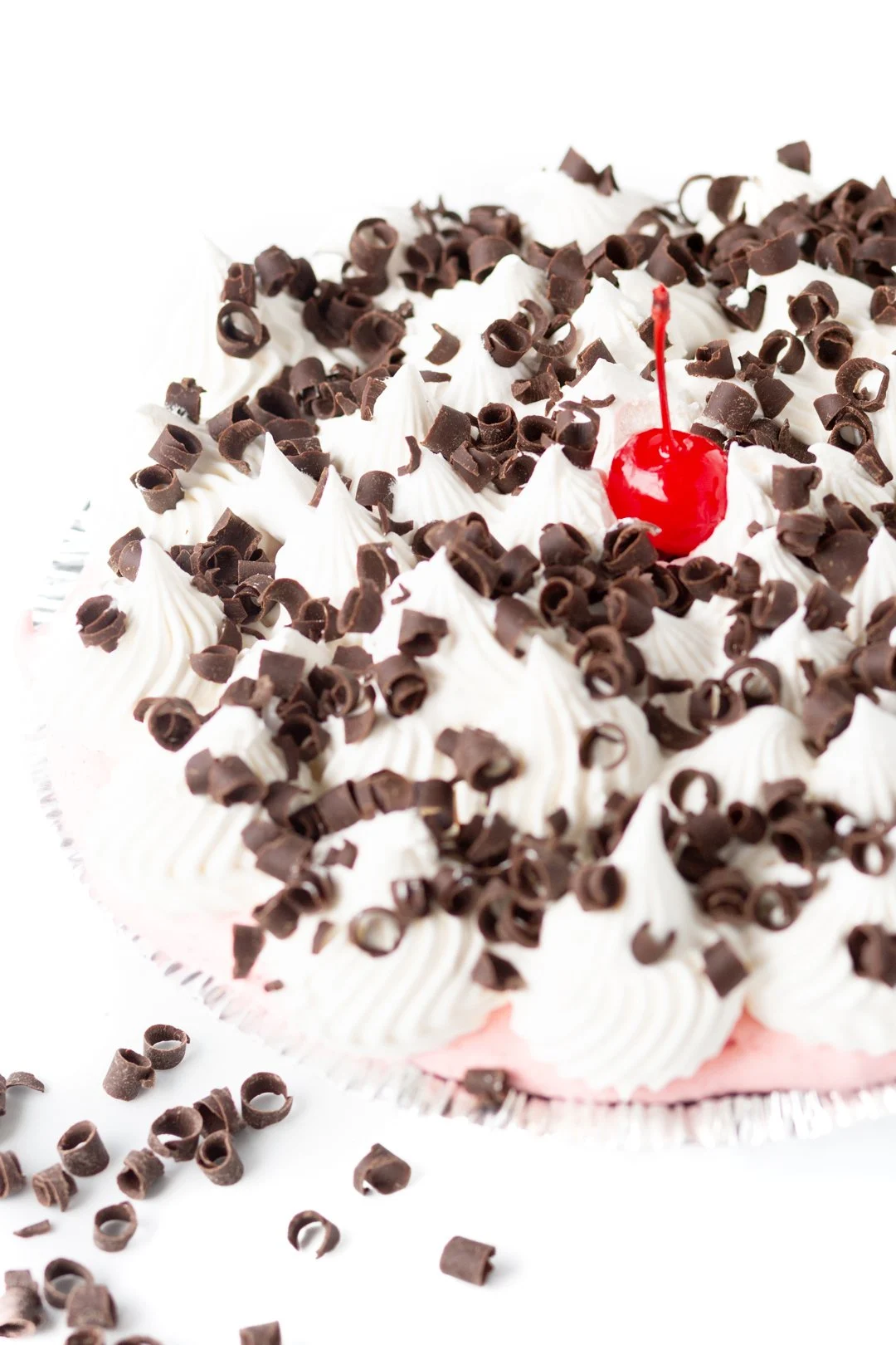 creamy pie topped with whipped topping, chocolate curls and a cherry