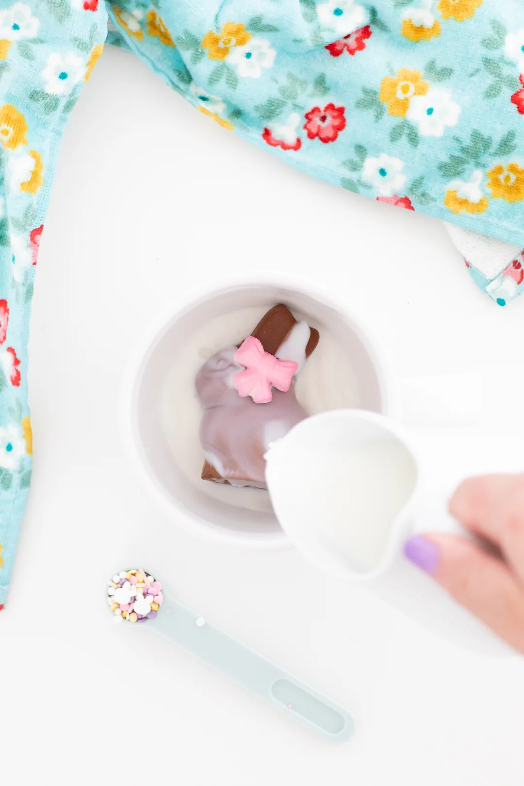 hot milk being poured over an easter bunny hot cocoa melt in a large mug