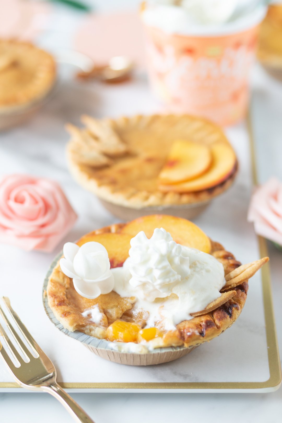 mini peach pie with ice cream and whipped cream on top.
