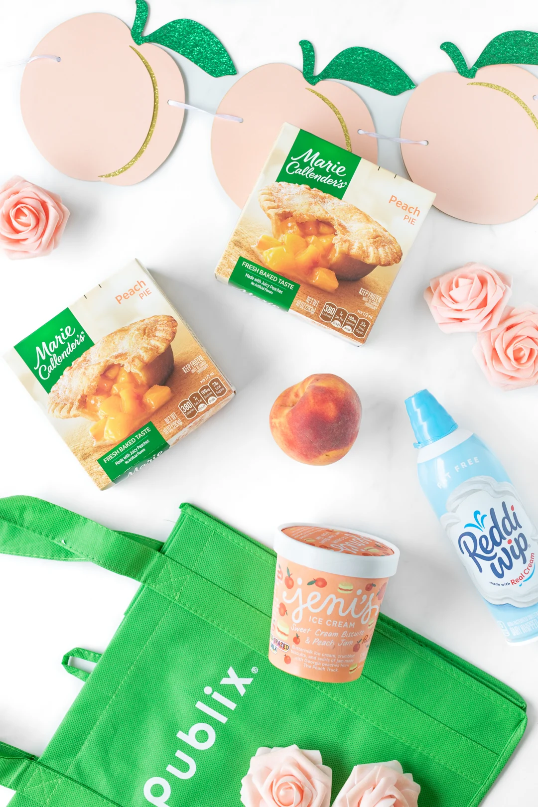 publix shopping bag with groceries including Jeni's ice cream, marie callendar's peach pies and Reddi-whip.
