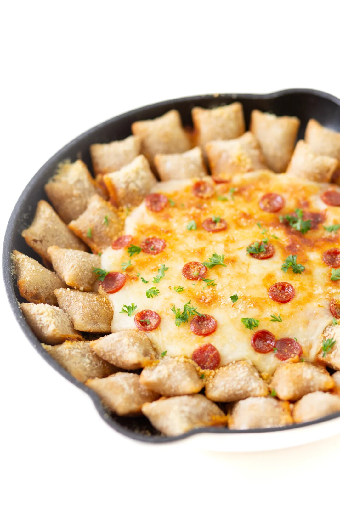 hearty dip made in a skillet with cheese, mini pepperoni and lined with pepperoni pizza rolls. Topped with snippets of parsley for garnish.