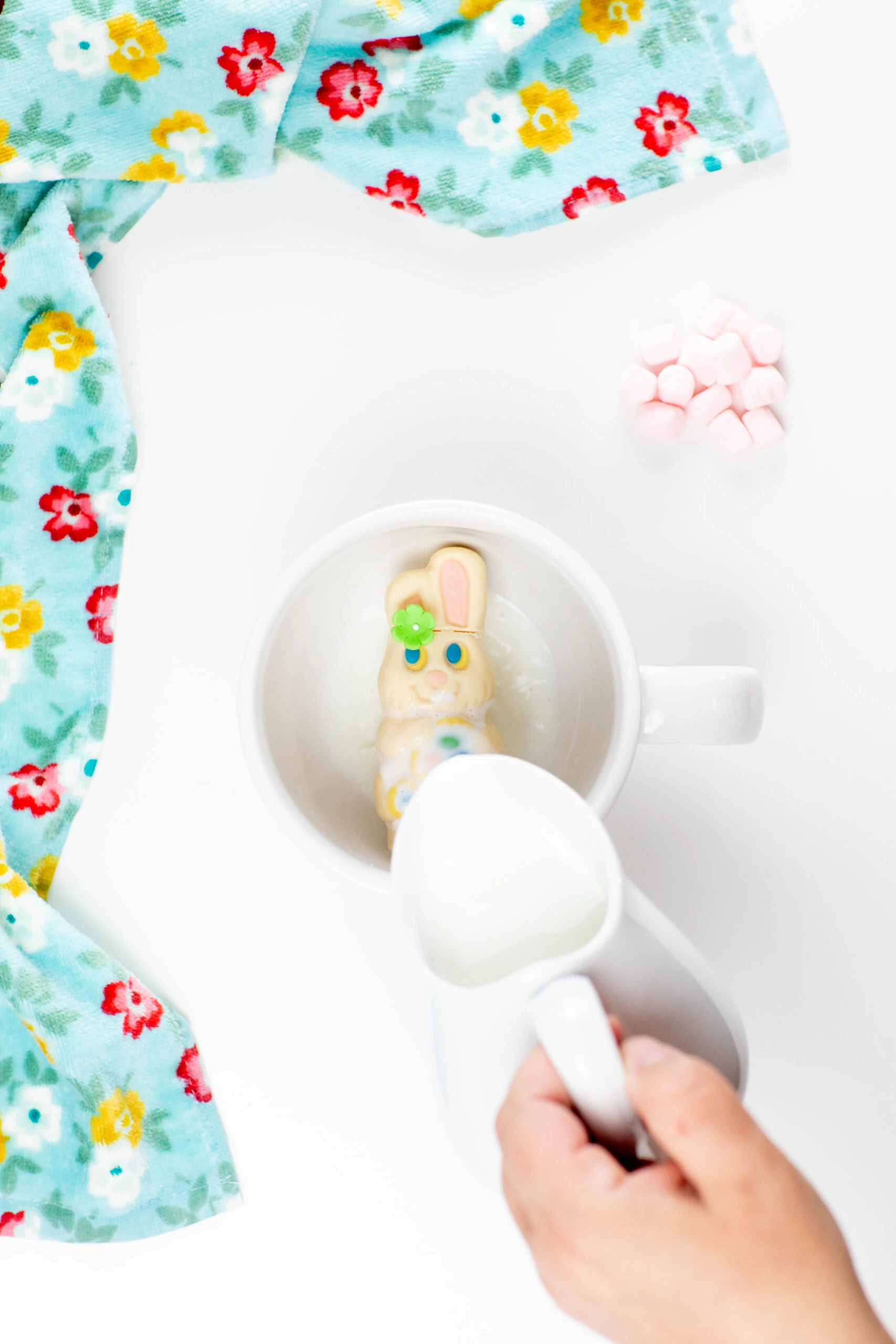 white chocolate hollow easter bunny in a mug with hot milk being poured on it to melt it