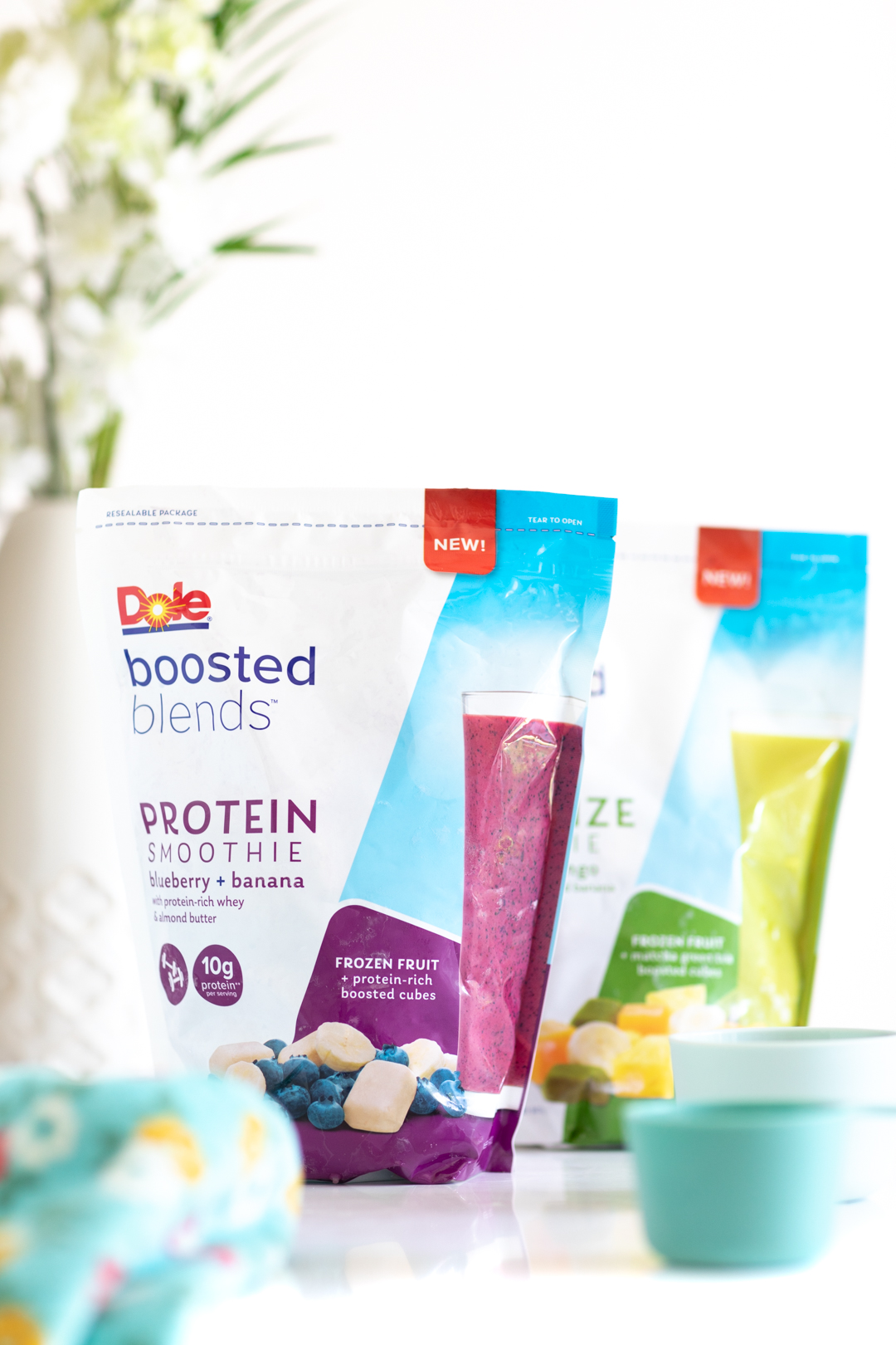 Dole Boosted Blends Protein variety in packaging on table with flowers