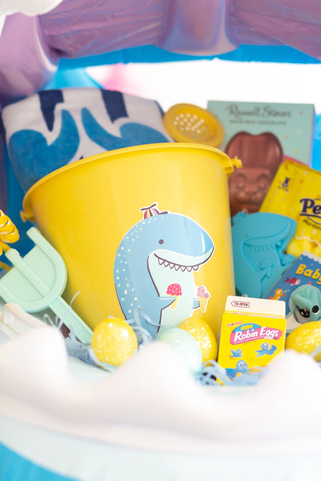 up close of shark easter basket with shark pail, beach towel, shovel, easter candy