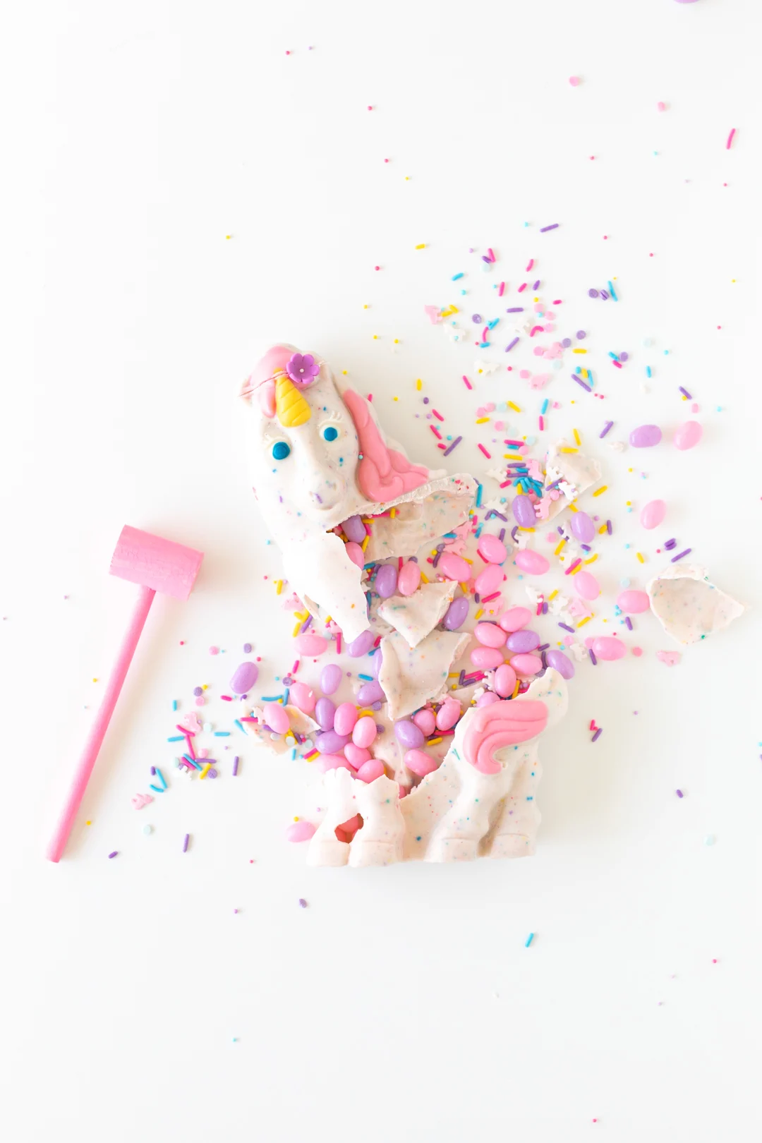 Smash unicorn with sprinkles and pastel jelly beans using a painted pink mini mallet