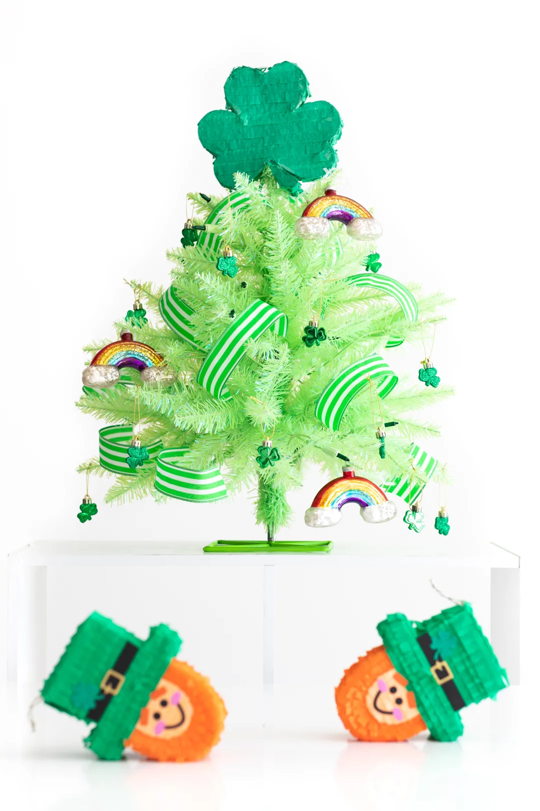 Mini green St. Patrick's Day tree, decorated with mini leprechaun piñatas nearby to decorate for St. Patrick's Day.