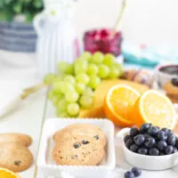 up close of a brunch board with crispy blueberry cookies and fresh fruits in the background