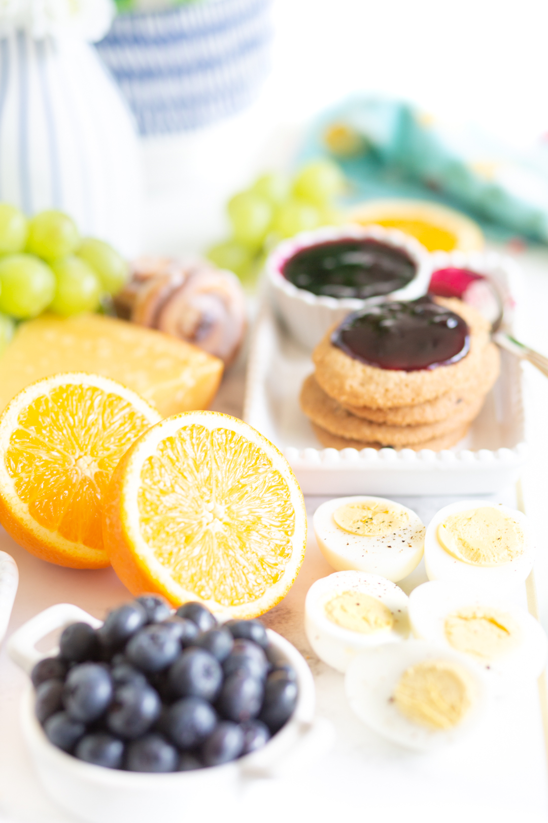 pretty brunch board with halved oranges, fresh blueberries, hard booked eggs