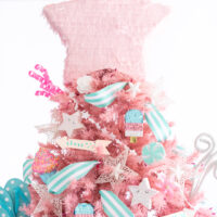 summer themed christmas tree with homage to patriotic holidays with stars, stripes and flip flops and popsicle pinatas as decorations