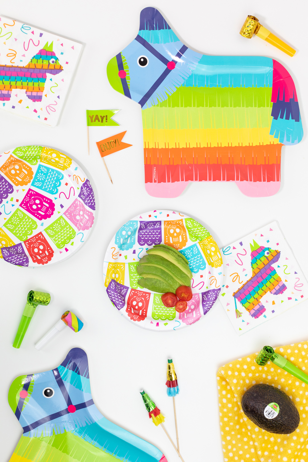 cinco de mayo party supplies and a sliced avocado on a festive plate