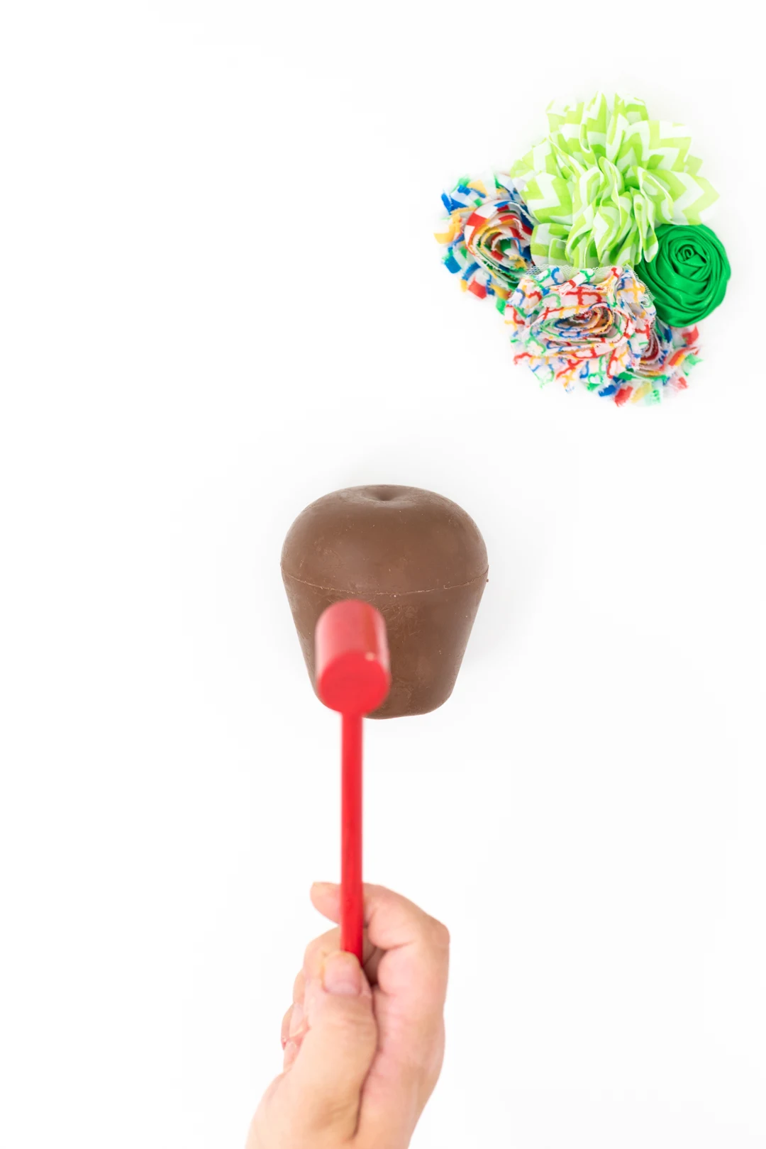 mini mallet being used to smash a pinata style chocolate apple filled with sprinkles and small candies