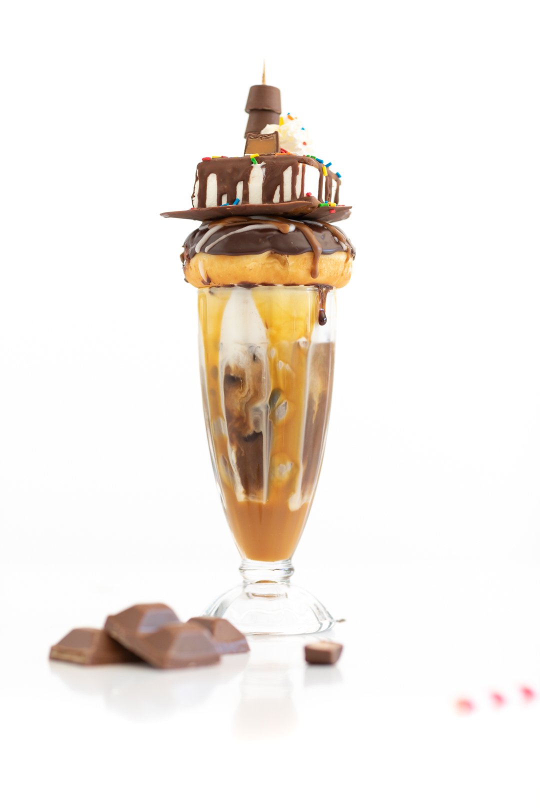 adding layers of sweets and desserts to the top of an iced coffee to make it fancy