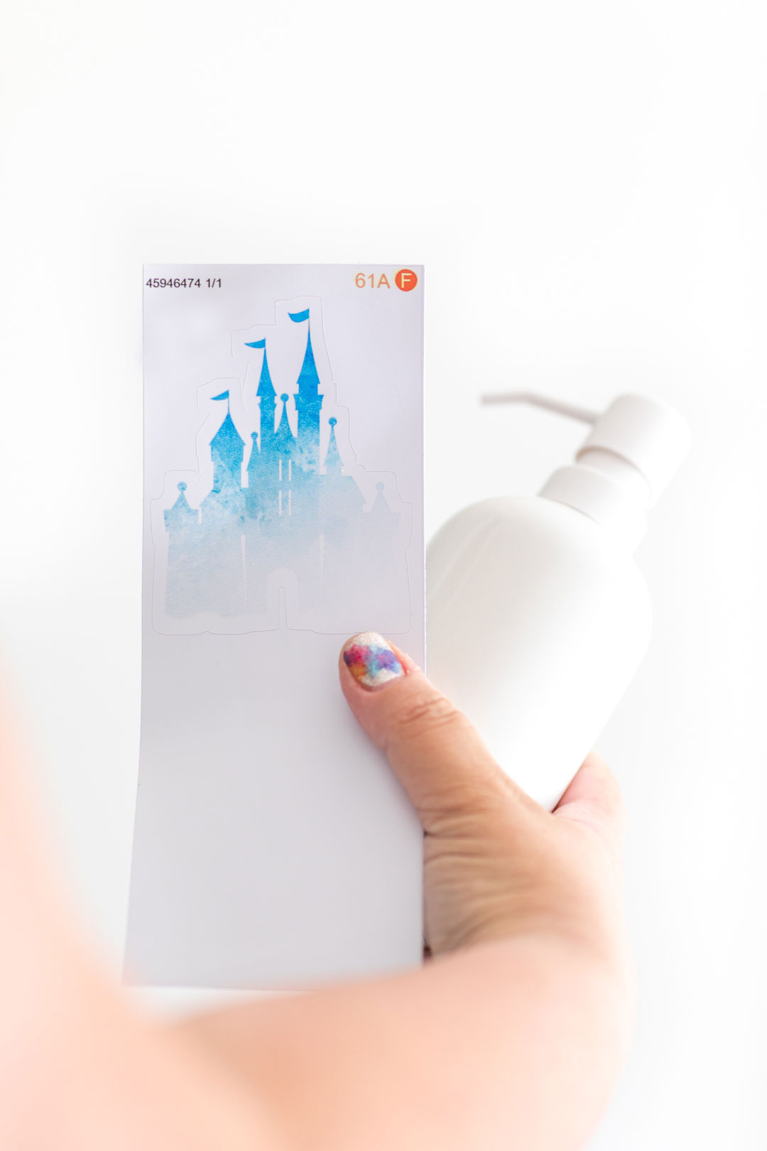 Giving a soap dispenser a makeover with a disney castle inspired sticker from redbubble.