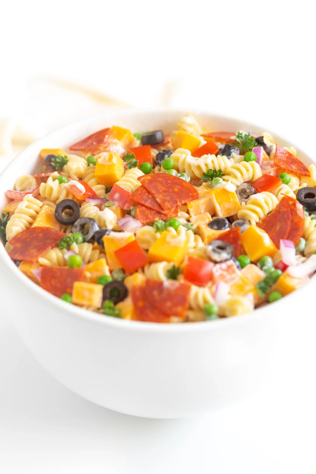 bowl of creamy pasta salad loaded with ingredients from chopped pepper to sliced pepperoni