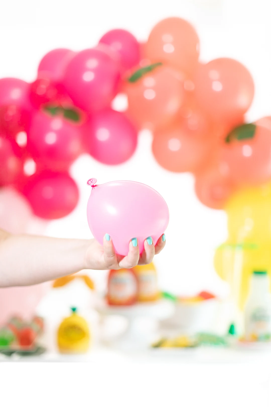 woman holding a water balloon in front of a party table
