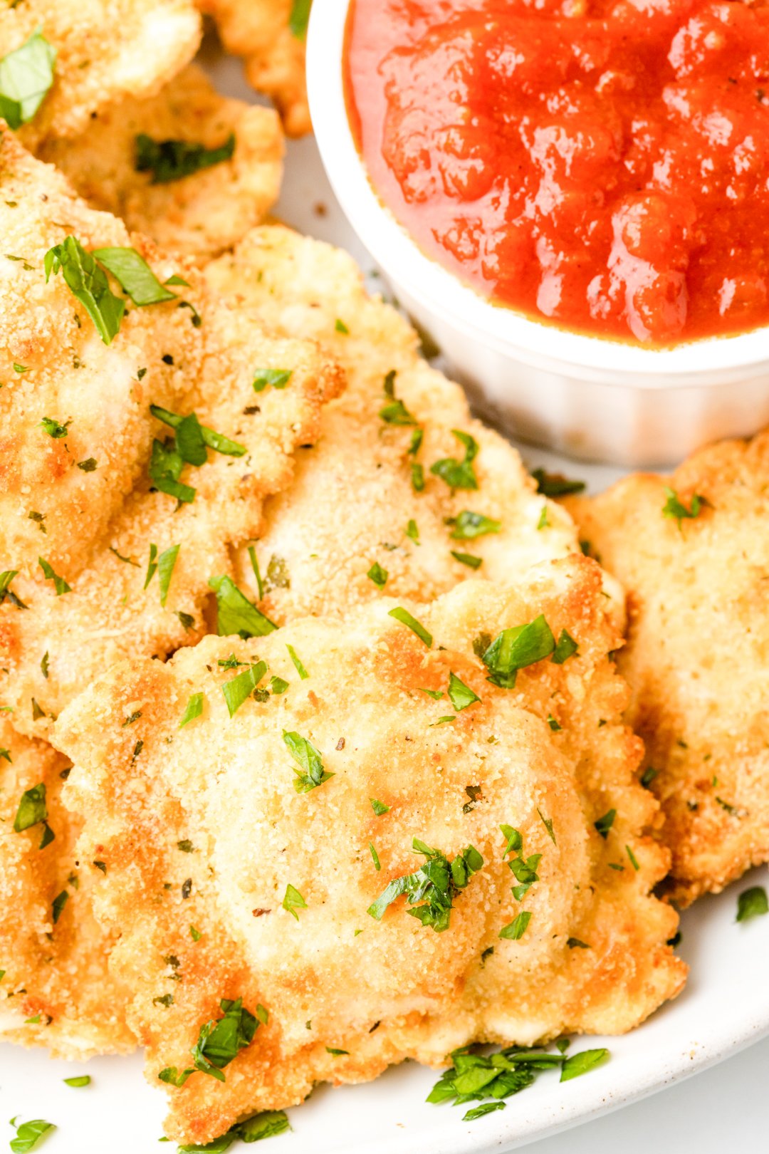 very up close photo of breaded ravioli appetizer with parsley garnish