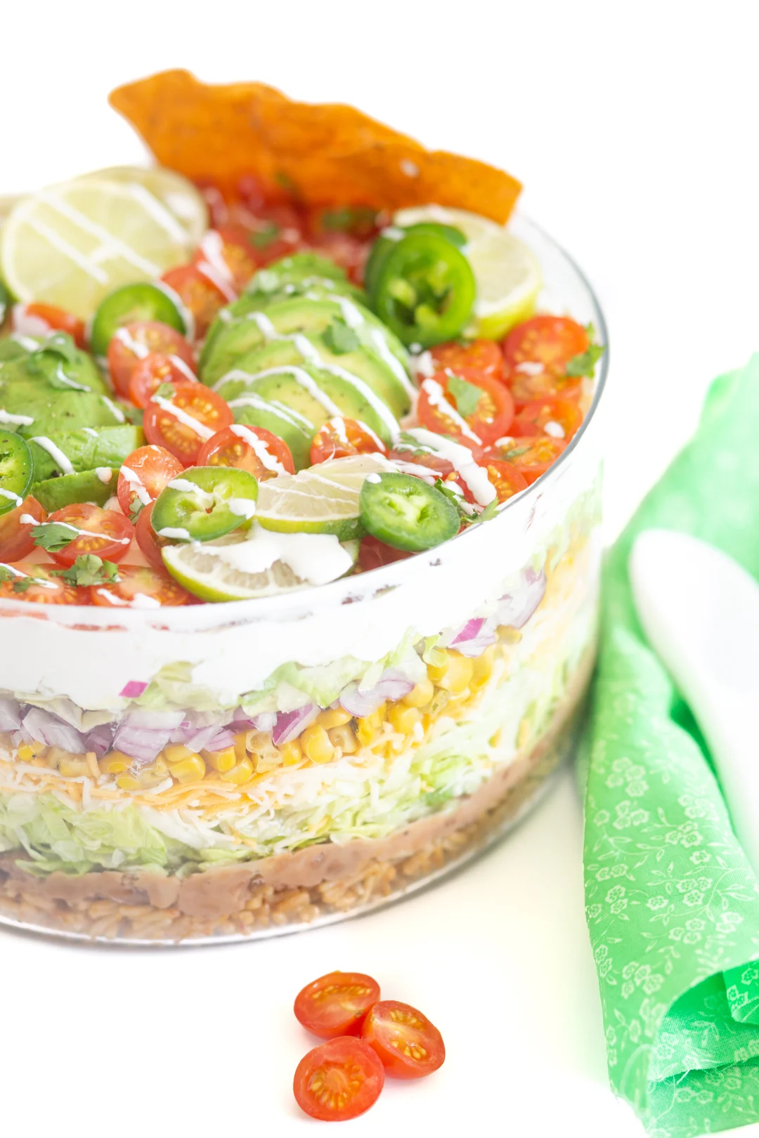 gorgeous mexican salad with pretty green cloth napkin and white spoon next to it