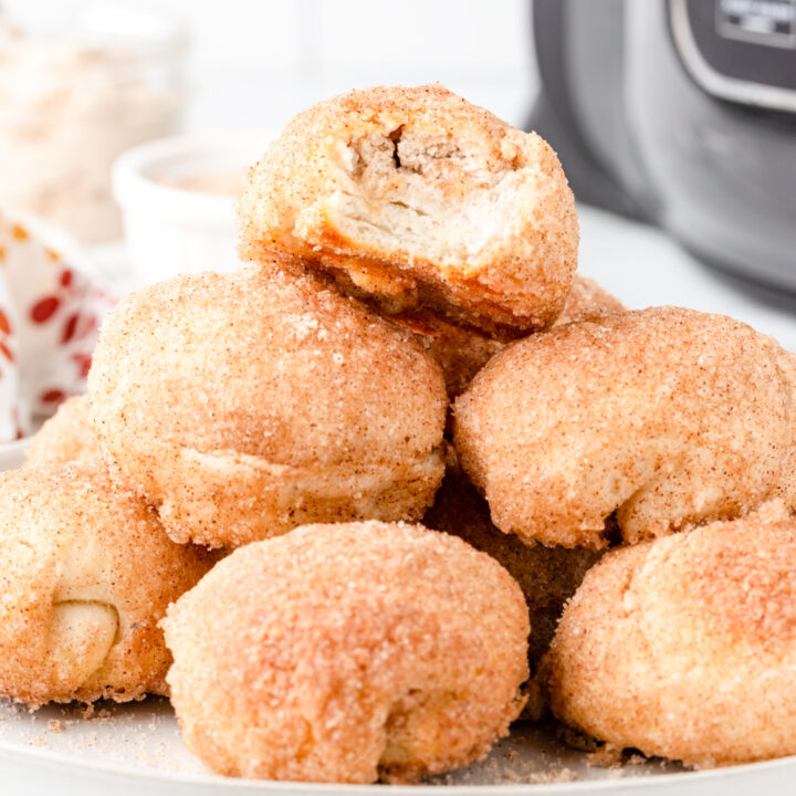 plate of donut bites with one on top with a bite taken out of it