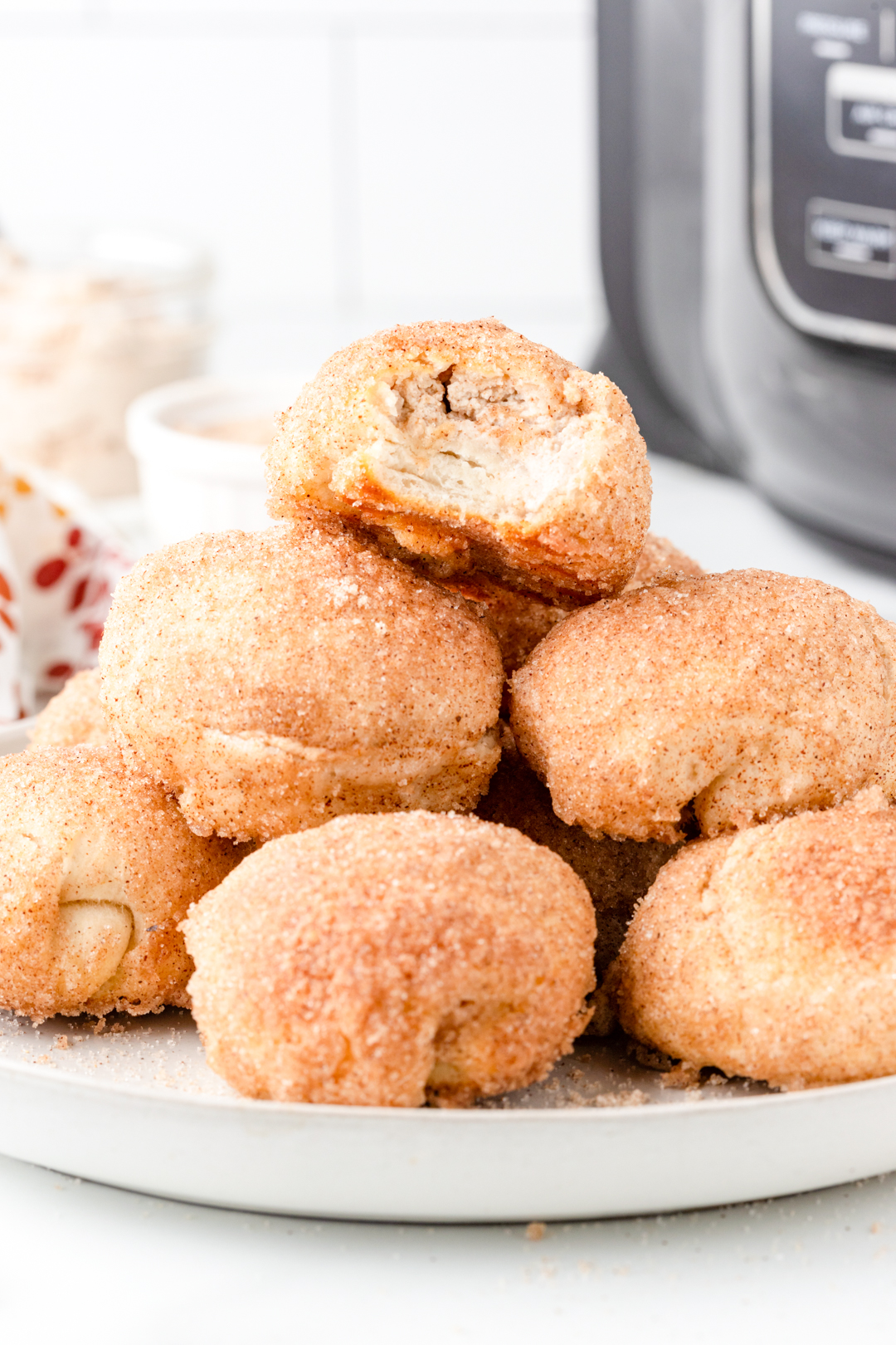 plate of donut bites with one on top with a bite taken out of it