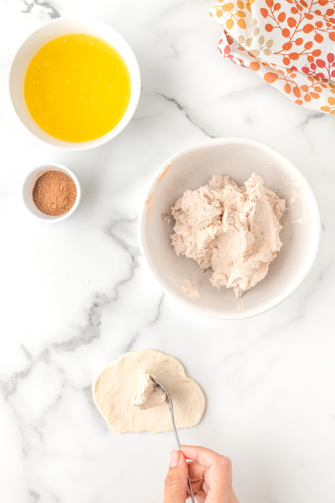 adding cream cheese mixture to center of uncooked canned biscuit