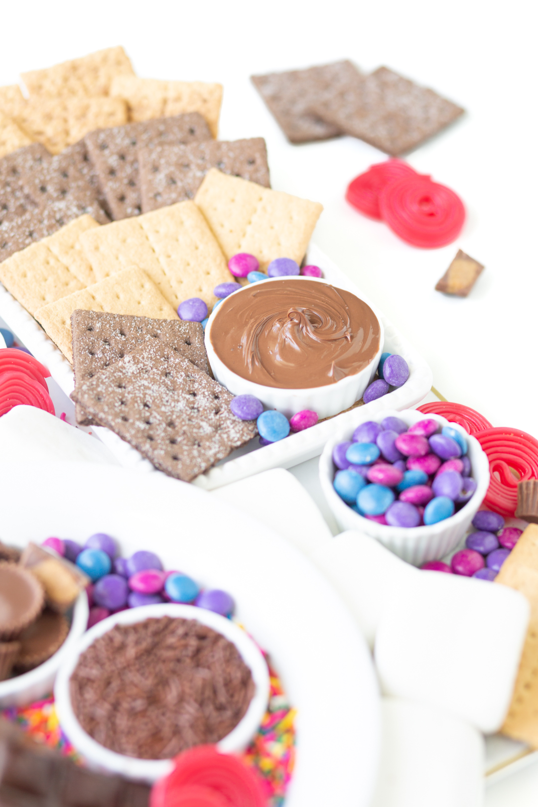 s'mores dessert grazing board with candies, spreads, graham crackers