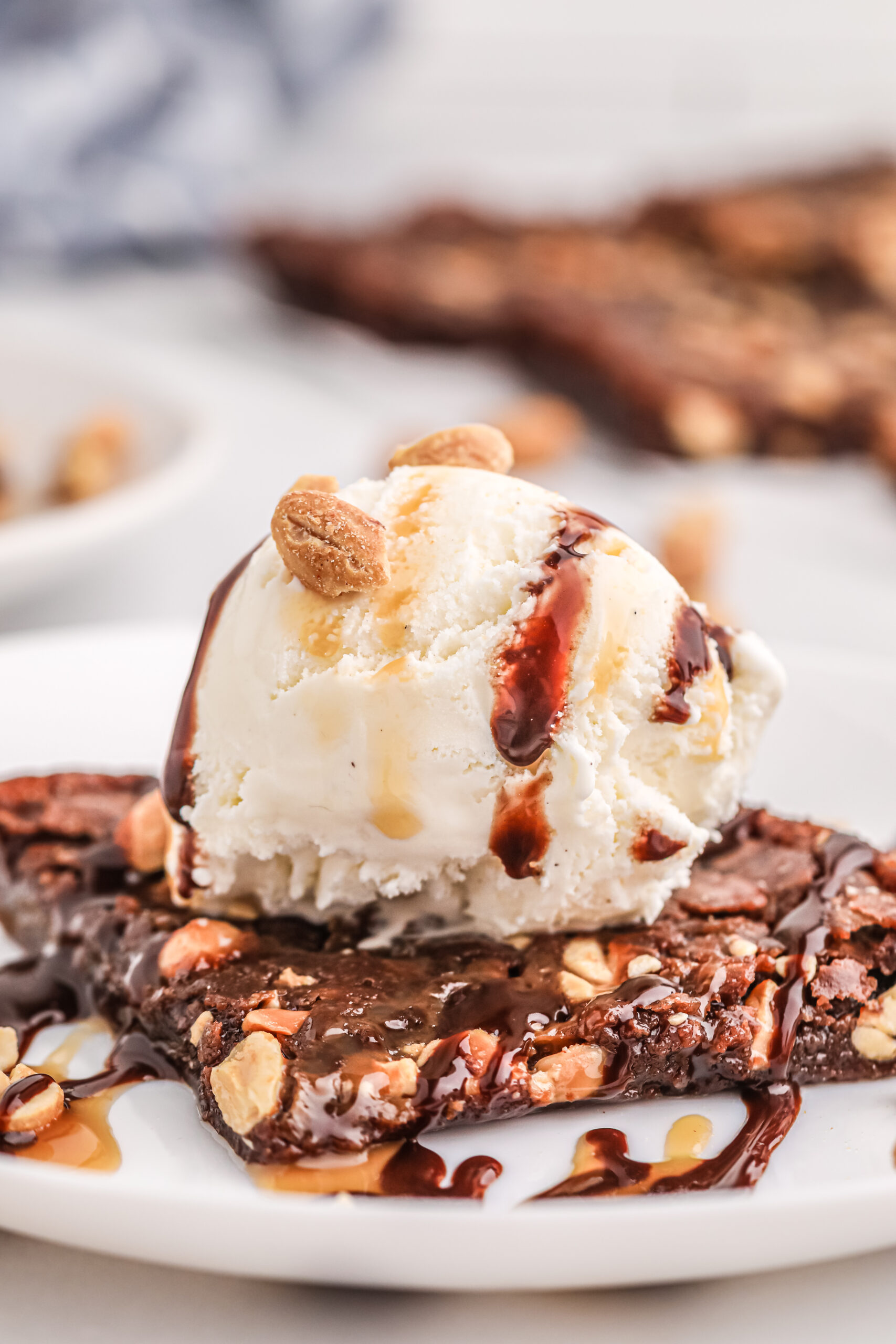 super up close view of thin brownie topped with ice cream scoop and chocolate and caramel drizzle