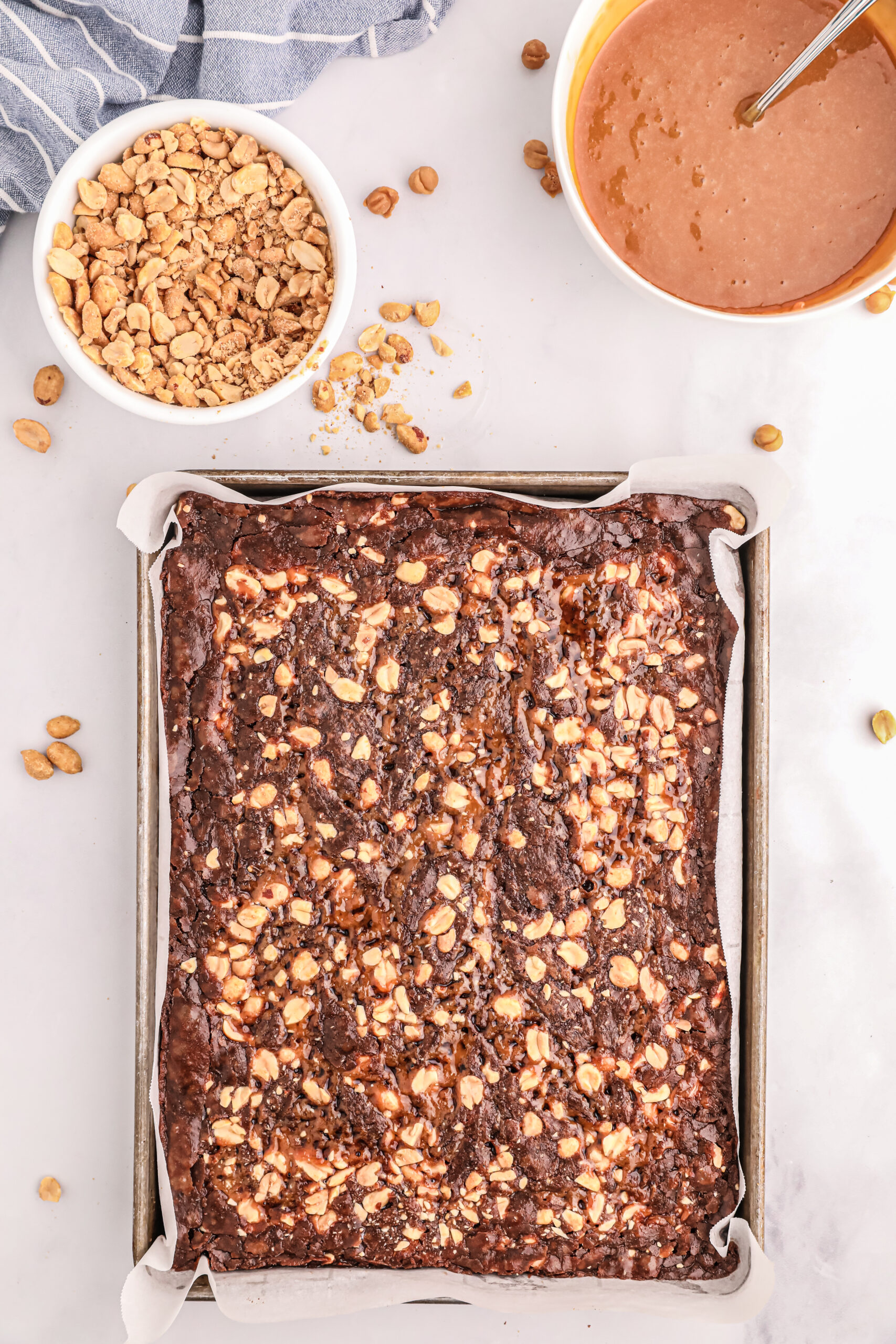 freshly baked snickers brownies on a baking sheet