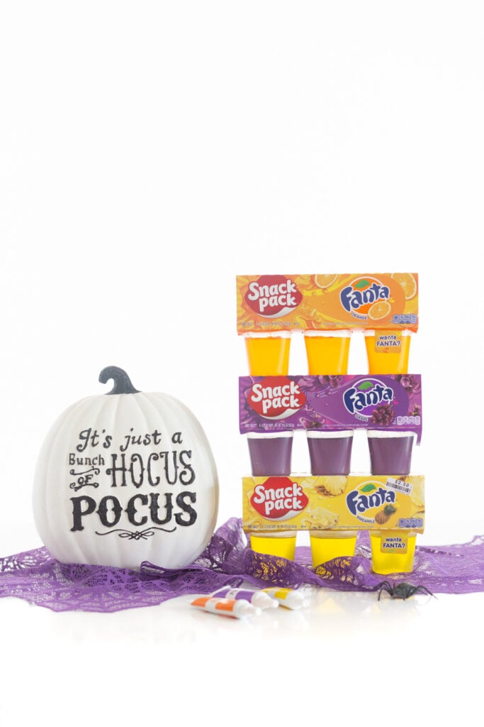 fanta gelatin cup packs. orange, pineapple and grape next to a ceramic decorative white pumpkin that reads "hocus pocus"