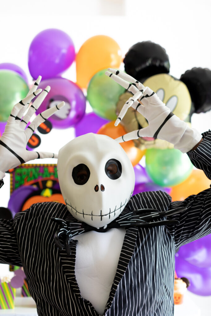 jack skellington costume posing in front of disney halloween party table