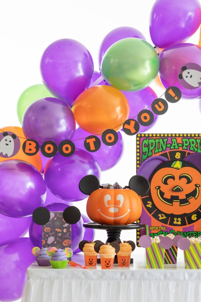 boo to you party with banner and balloons in green, orange and purple theme