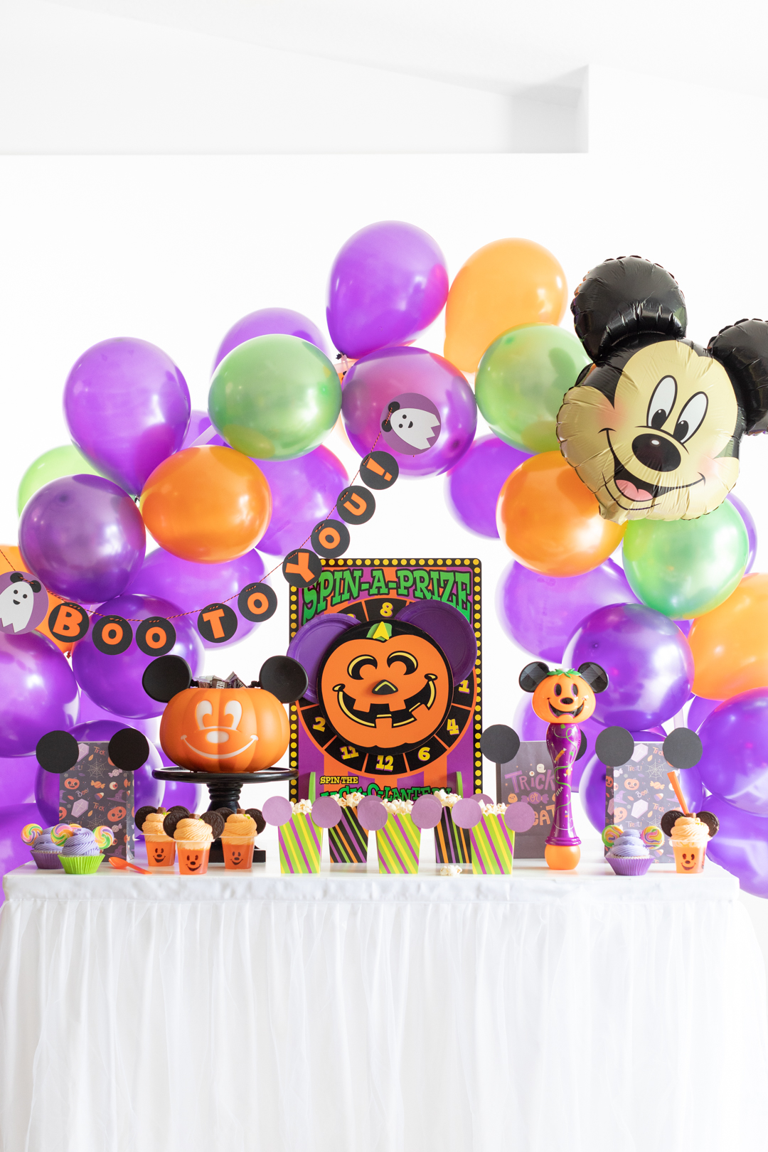 boo to you disney halloween party at home party table. green, purple, orange theme with large mickey mouse balloon