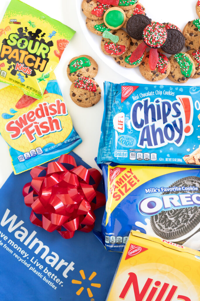 walmart haul with packages of sour patch kids, swedish fish, chips ahoy! oreo, nilla wafers, walmart reusable bag with a big red Christmas bow on it