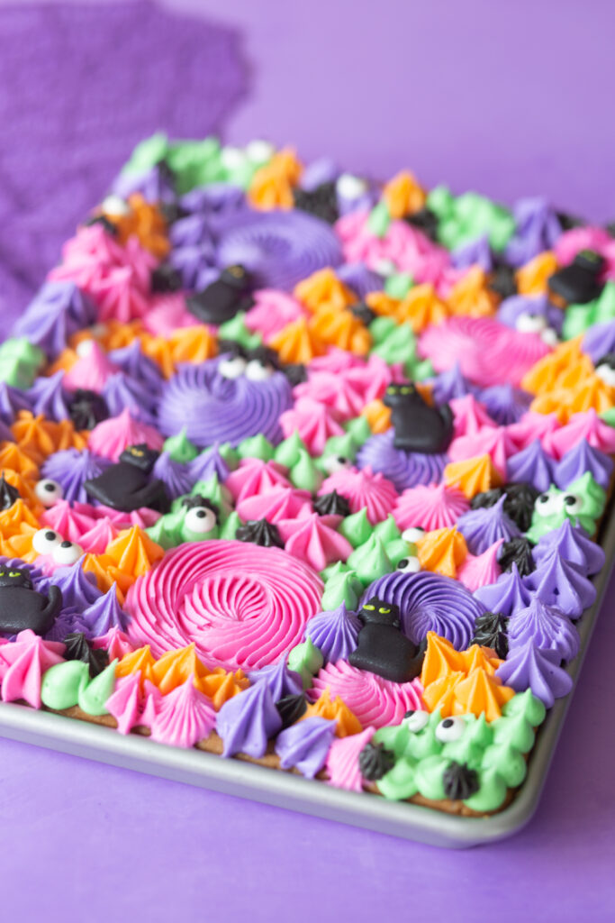 angled photo of half baking sheet cookies loaded with tinted buttercream frosting