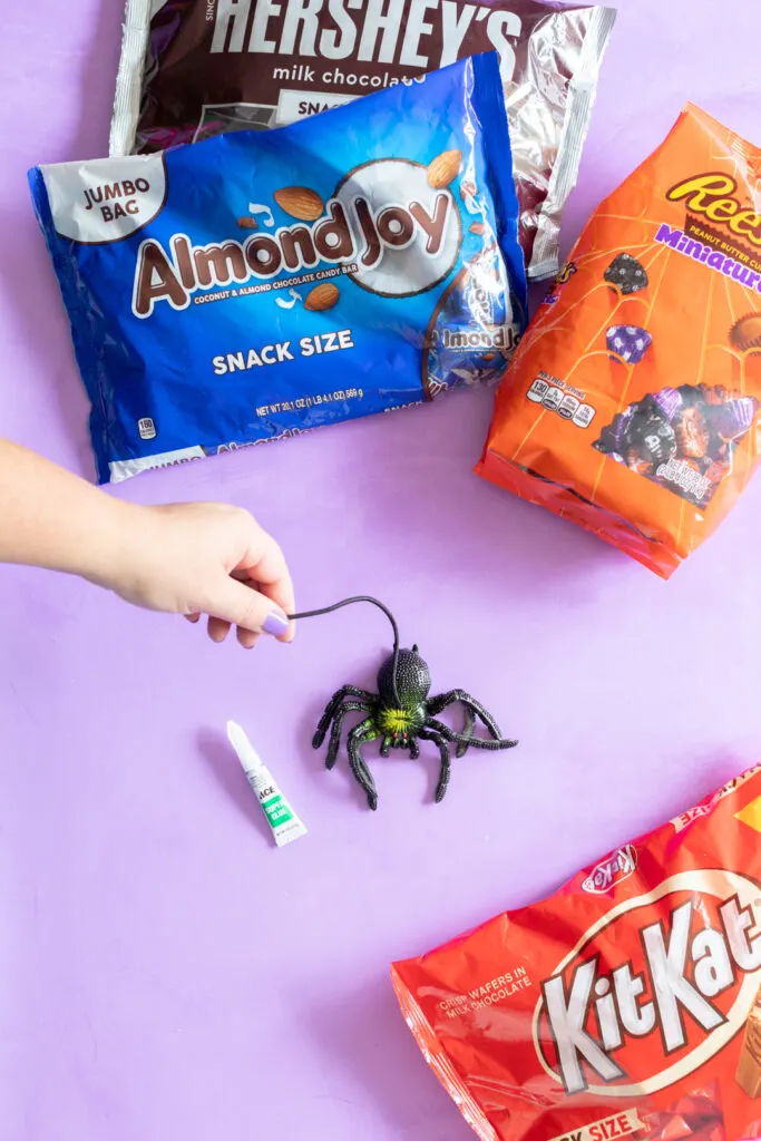 glueing a black elastic string to a rubber prank spider for a halloween prank