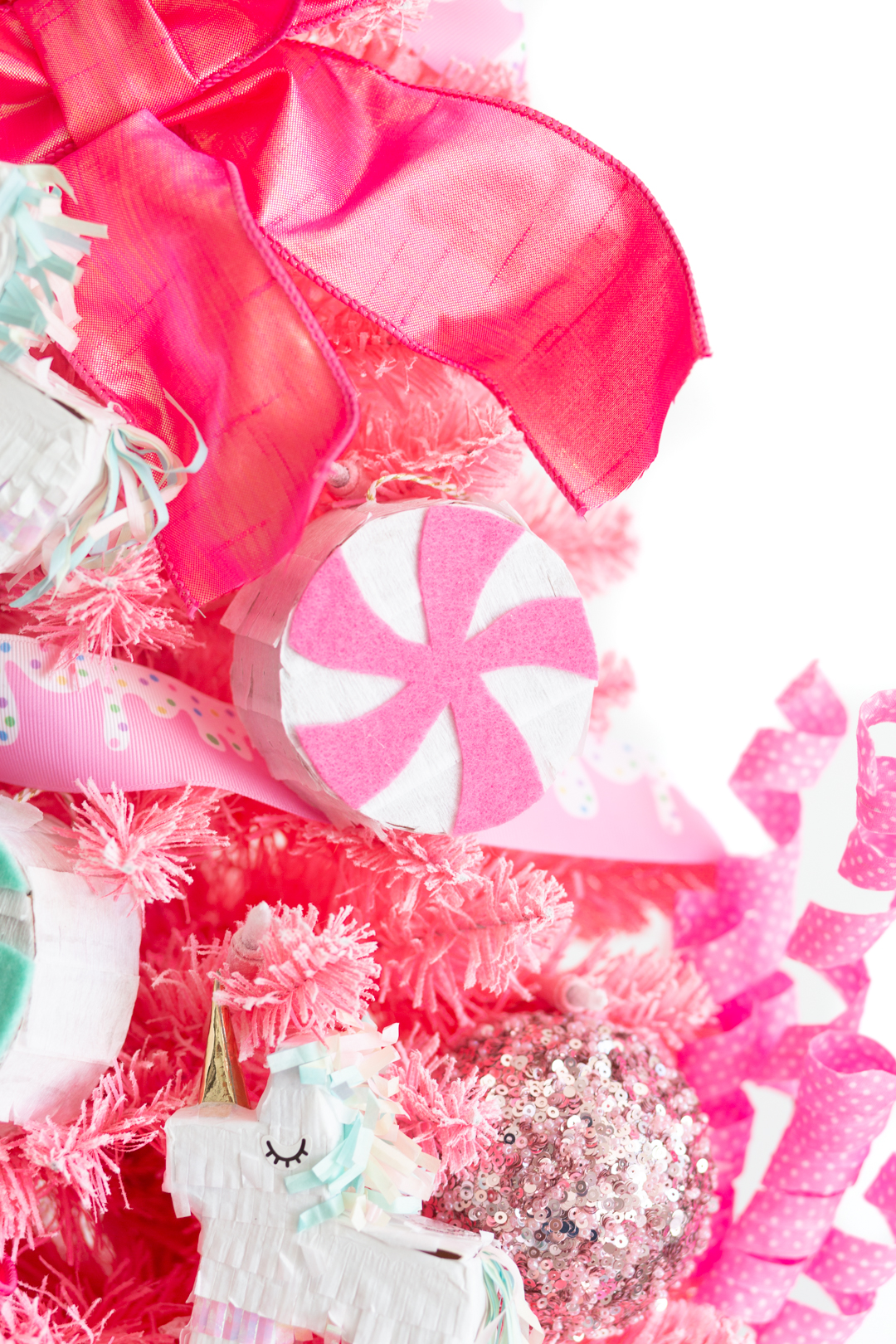 mini pink peppermint pinata ornament on a candy pink christmas tree