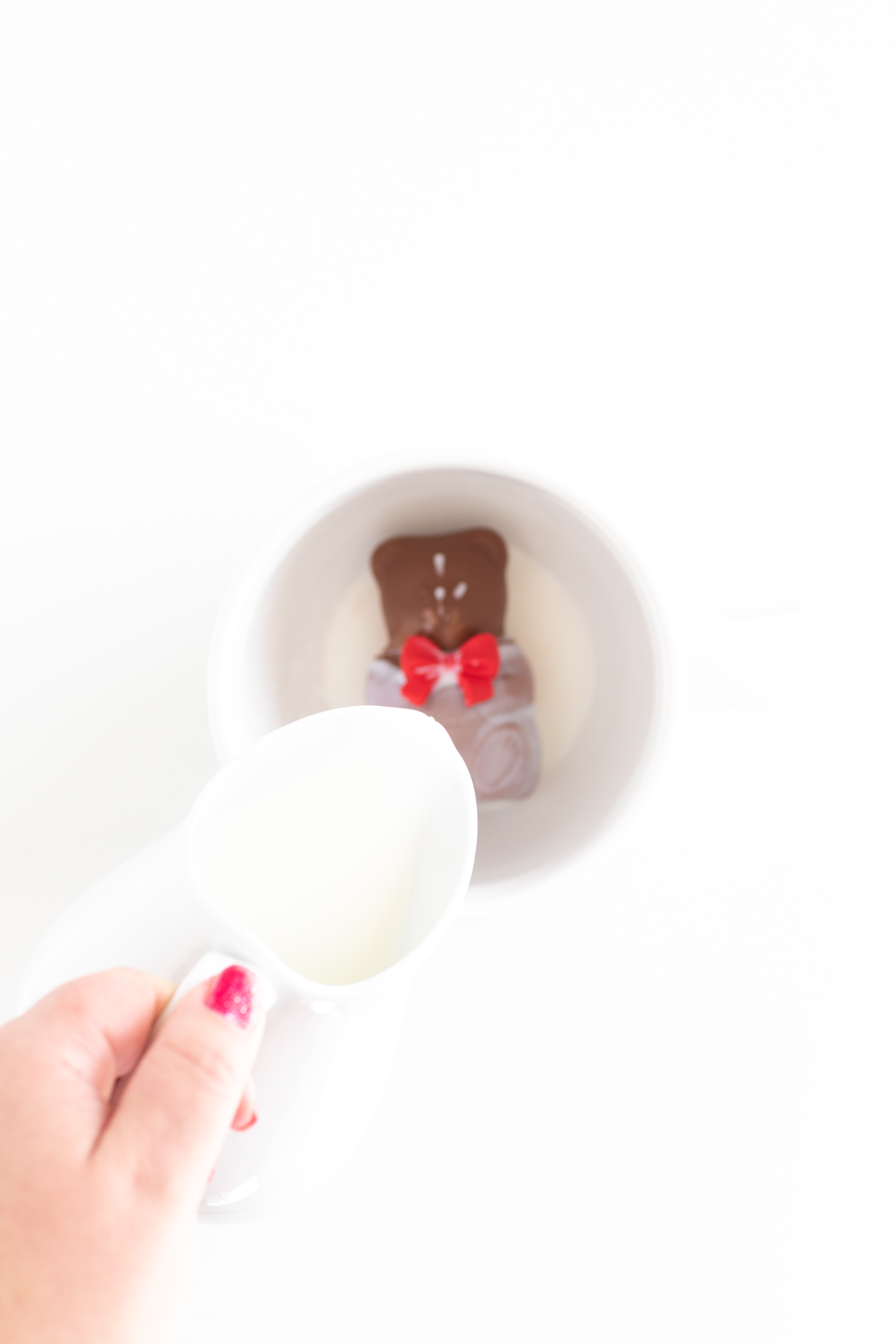 hot milk being poured over a teddy bear hot cocoa melt in a mug