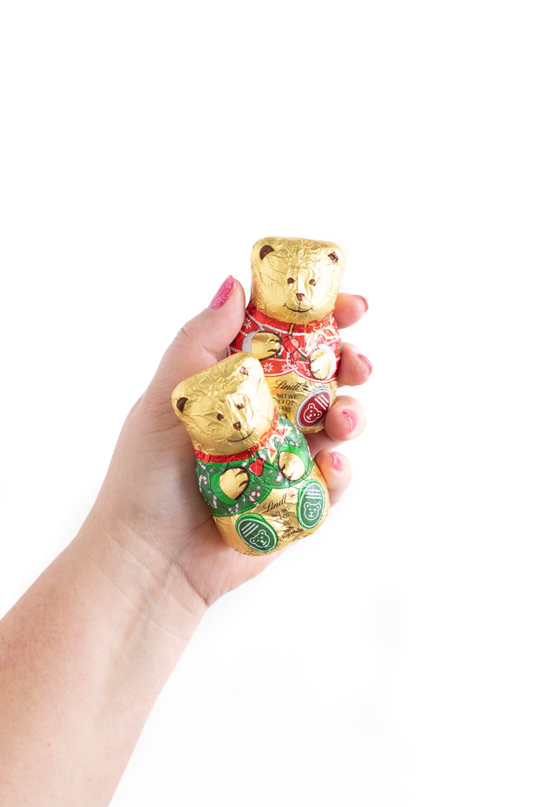 a woman holding two foil wrapped golden chocolate bears