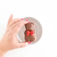 woman holding a chocolate teddy bear hot cocoa melt over an empty white mug