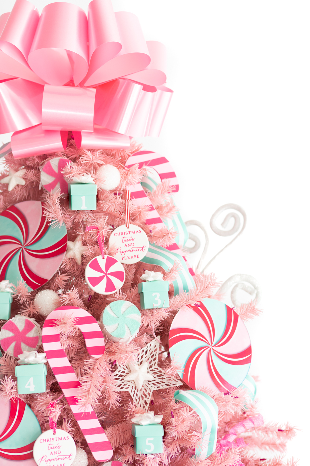 upper view of decorated pink christmas tree with extra large pink bow on top