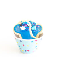 galaxy themed blue alien dog bone cookies in a cute small polkadot bowl