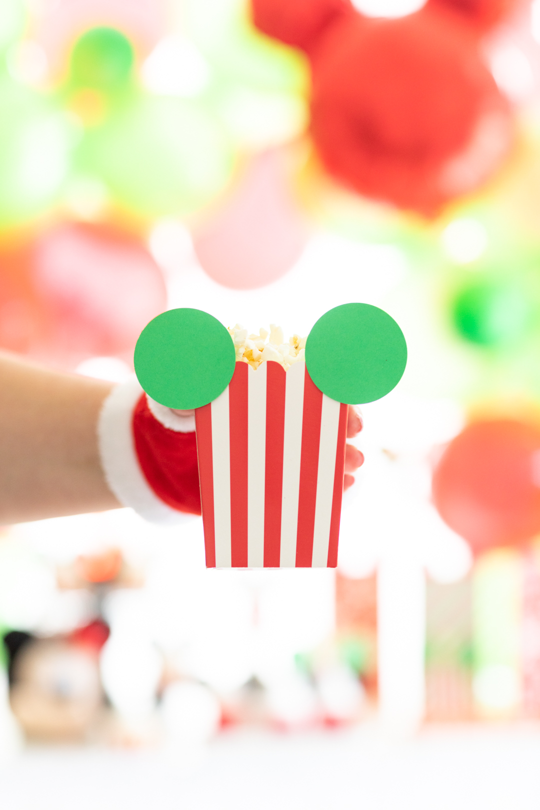 mickey mouse popcorn box . red and white popcorn box with green cut out mickey mouse ears and filled with popcorn