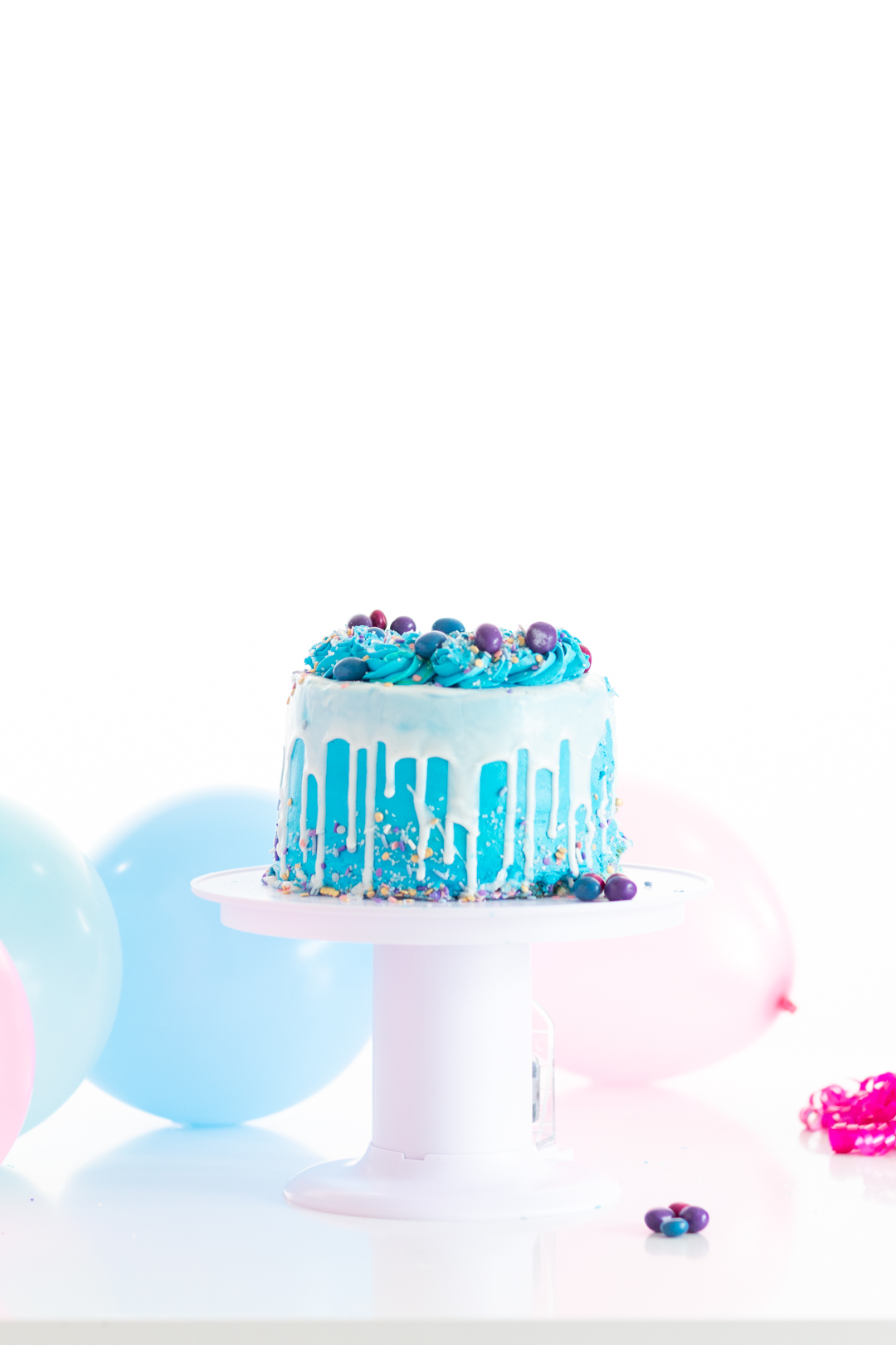 pretty blue cake with white icing set on a surprise cake stand