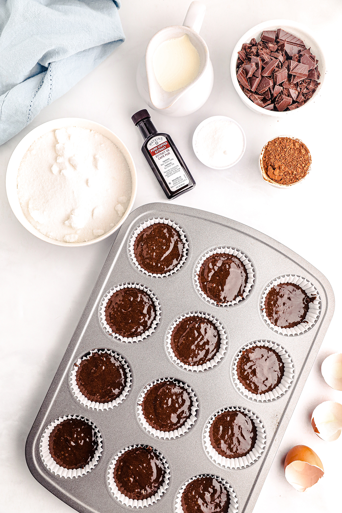 over the top view of chocolate cupcake batter in cupcake liners in a cupcake tin