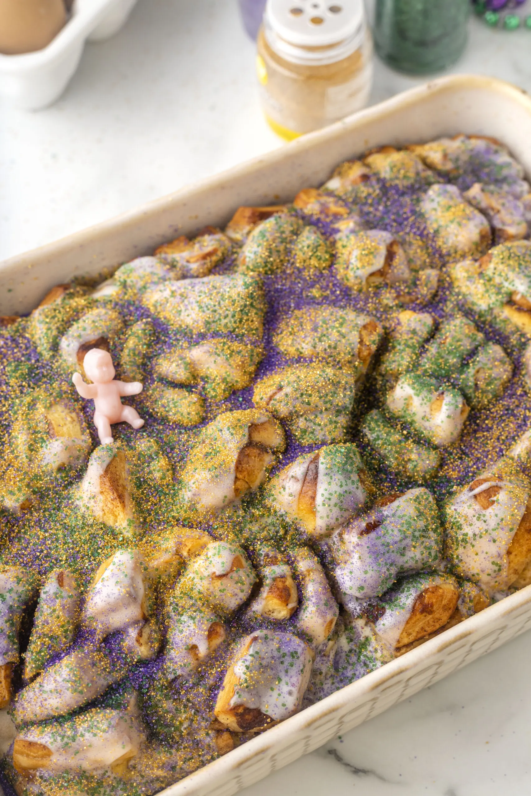 close up image of bubble up king cake with a tiny baby on top of the cooked casserole