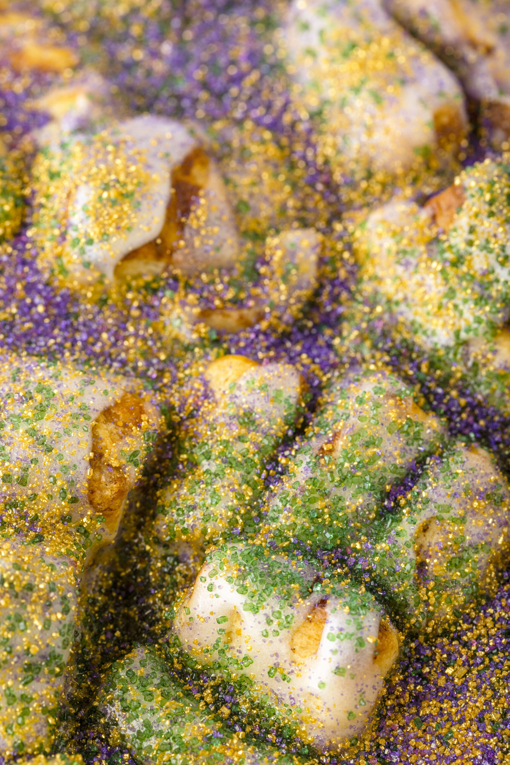 close up of bubble up king cake topped with purple, green and yellow sprinkles