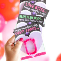 up close view of a woman holding printed hotel Transylvania valentine's cards for kid's exchanges.