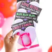 up close view of a woman holding printed hotel Transylvania valentine's cards for kid's exchanges.
